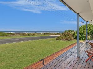 a porch with a bench and a view of the ocean at Seaclusion in Port Fairy