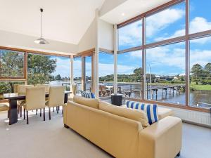 sala de estar con ventanas grandes, mesa y sillas en Shearwater House, en Port Fairy