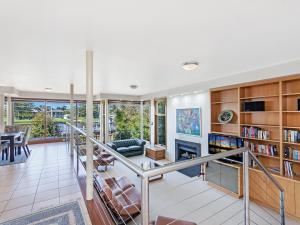 a living room with a staircase and a fireplace at Shearwater Riverview Apartment in Port Fairy