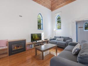 a living room with a couch and a fireplace at The Church in Port Fairy