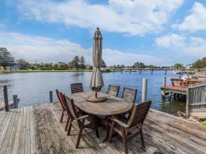a wooden table with an umbrella on a dock at The Moorings in Port Fairy