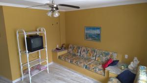 a living room with a couch and a tv at Bertioga-Costa do Sol MK9 in Praia Guaratuba