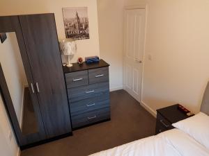 een slaapkamer met een dressoir en een spiegel bij Liverpool Anfield in Liverpool