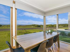 a dining room with a table and chairs and a large window at The Waves in Port Fairy