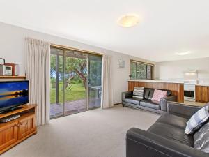 a living room with a couch and a tv at Waters Edge in Port Fairy