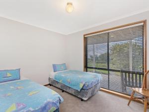 - une chambre avec 2 lits et une grande fenêtre dans l'établissement Waters Edge, à Port Fairy