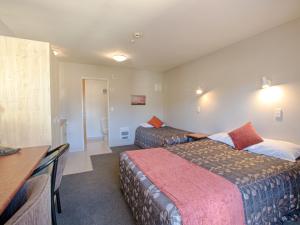 a hotel room with two beds and a table at Bella Vista Hanmer Springs in Hanmer Springs