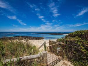 a beach with a wooden fence and the ocean at Wytonia 1 in Port Fairy