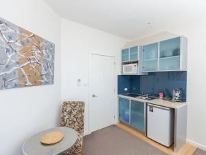 a small kitchen with blue cabinets and a table at Wytonia 3 Penthouse in Port Fairy