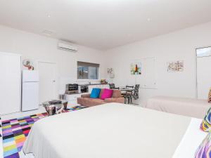 a white room with a bed and a couch at Wytonia Cabana in Port Fairy