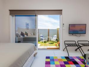 a bedroom with a bed and a view of a patio at Wytonia Cabana in Port Fairy
