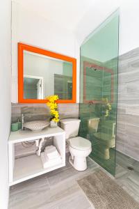 a bathroom with a toilet and a glass shower at Studio 7 - Oceanfront Apartment in Nassau
