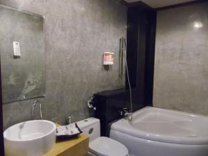een badkamer met een wastafel, een toilet en een bad bij Charming Lao Hotel in Ban Chéng