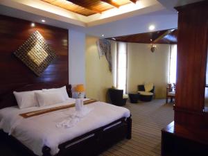 um quarto de hotel com uma cama grande com lençóis brancos em Charming Lao Hotel em Ban Chéng