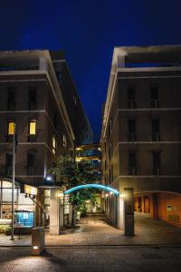 松山的住宿－多格酒店，一条城市街道,晚上有两栋高大的建筑