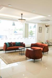 a living room with two couches and a table at Savana Hotel & Serviced Apartments in Kuala Perlis