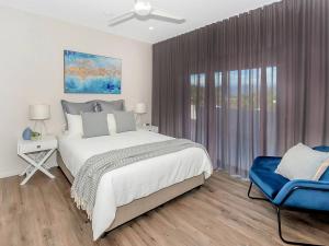 - une chambre avec un grand lit et une chaise bleue dans l'établissement Superior Luxury Apartment in the City, à Cairns