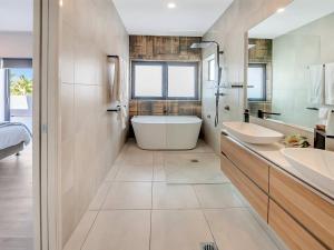 a bathroom with two sinks and a bath tub at Superior Luxury Apartment in the City in Cairns