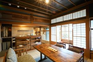 a large kitchen with a wooden table and chairs at Bed and Craft MITU in Nanto