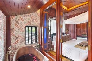 a bath tub in a room with a bedroom at Aksorn Rayong, The Vitality Collection - SHA PLUS in Klaeng