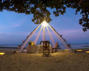 a tent on the beach with a table and chairs at Phi Phi Relax Beach Resort in Phi Phi Islands