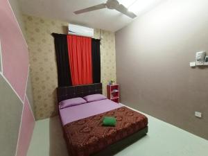 um quarto com uma cama e uma cortina vermelha em Kak Chik Muslim Homestay em Kepala Batas
