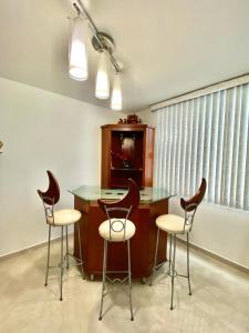 a kitchen with a table and two stools at Condominio Renoir in Mexico City
