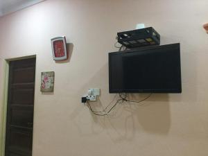 a tv on a wall with a video game system on it at Rose Homestay Padang Besar in Padang Besar