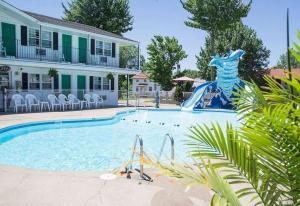 a swimming pool with a slide in front of a house at Colonial motel in Wisconsin Dells +20 photos