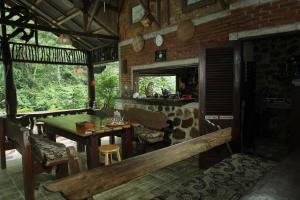 a dining room with a wooden table and a bench at Kupu Kupu Garden Guest House & Cafe in Bukit Lawang
