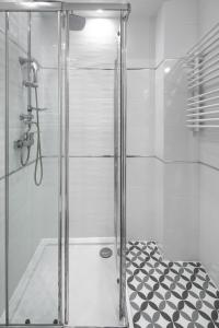 prysznic ze szklanymi drzwiami i czarno-białą podłogą w obiekcie Native Apartments Starowiślna 33A Deluxe w Krakowie +19 zdjęć