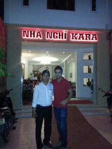 two men standing in front of a nima night kaza at Kara Beachside Guesthouse in Da Nang