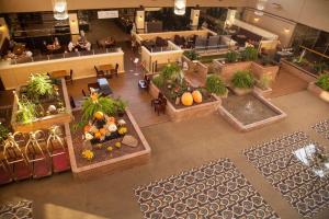 einen Blick über eine Lobby mit Pflanzen und Tischen in der Unterkunft Medicine Hat Lodge, Trademark Collection by Wyndham in Medicine Hat