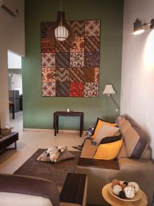 a living room with a couch and a quilt on the wall at Richbaliz Homestay @ Selayang Jaya in Batu Caves