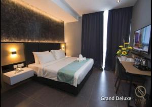 a hotel room with a large bed and a desk at Solid Hotels in Johor Bahru