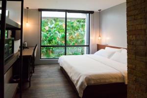 a bedroom with a bed and a large window at JonkeRED Heritage Hotel in Malacca