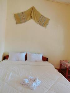 - un lit blanc avec une fleur au-dessus dans l'établissement Sythane Guesthouse, à Nongkhiaw