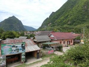 a group of buildings with mountains in the background at Sythane Guesthouse in Nongkhiaw