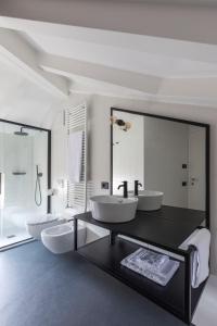 a bathroom with two sinks and a large mirror at Casa Trentini - Atemporary Art Apartments in Trento