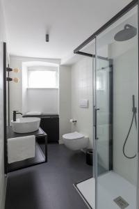 a bathroom with a glass shower and a toilet at Casa Trentini - Atemporary Art Apartments in Trento
