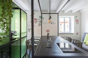 Casa Trentini - Atemporary Art Apartments في ترينتو: غرفة طعام مع طاولة وكراسي زجاجية