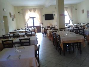 una sala da pranzo con tavoli, sedie e TV di La Pania a Stazzema
