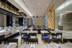 um restaurante com mesas e cadeiras e um bar em Savoy Hotel Mactan em Mactan