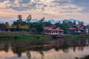 a group of houses on the side of a river at Sayong Resort in Kuala Kangsar