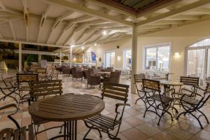 a dining room with tables and chairs and a cafeteria at Alykanas Village Resort in Alikanas