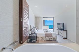 une chambre avec un lit, une baignoire et une télévision dans l'établissement Executive on Whisper Bay - Cannonvale, à Airlie Beach 20 autres photos
