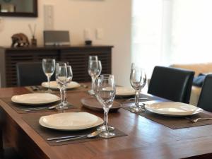 a wooden table with plates and wine glasses on it at Moriyuki in Furano