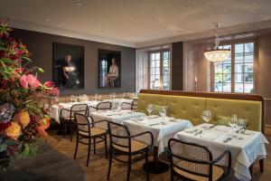 ゾロトゥルンにあるLa Couronne Atelier - Dependanceの白いテーブルと椅子、シャンデリアのあるレストラン