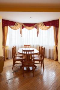 ein Esszimmer mit einem Tisch, Stühlen und einem Fenster in der Unterkunft Hotel Obolon in Kiew