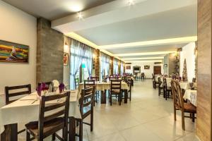 a dining room with tables and chairs in a restaurant at Family Hotel BOHEMA in Ognyanovo